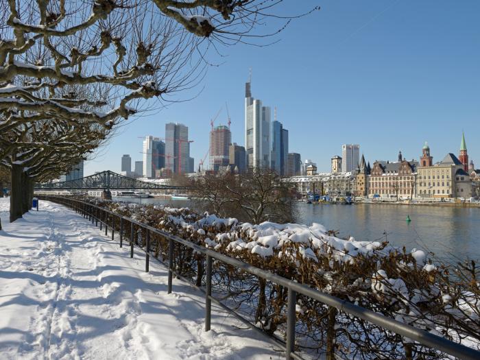 Mainufer in Frankfurt im Winter, Spuren im Schnee, Hochhäuser in der Ferne